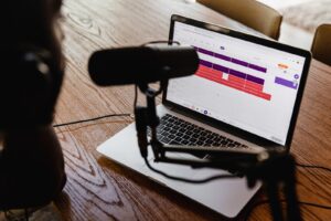 macbook pro on brown wooden table - how to start a podcast