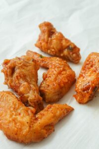 fried chicken on white paper - how to cook chicken wings the best