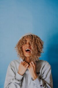 how to be witty - smiling woman wearing gray hoodie