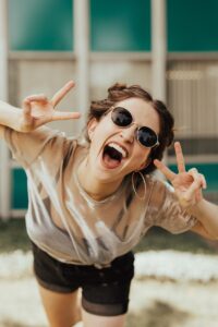 How to Be Happy with Yourself selective focus photography of jolly woman using peace hand gesture