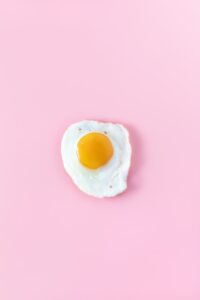 sunny side up egg on pink surface